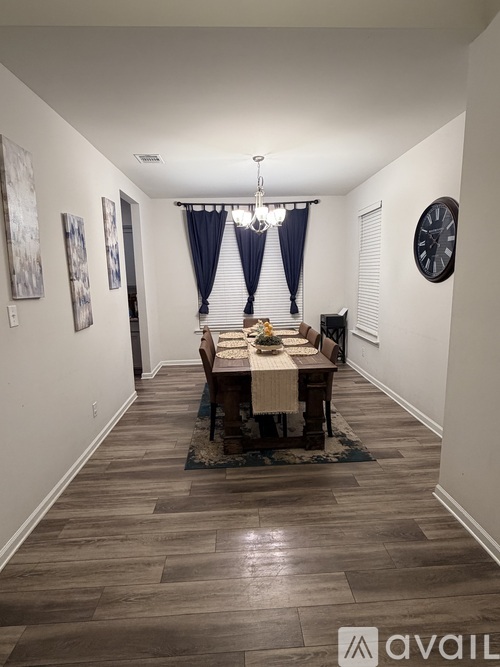 A dining room with a wooden table and chairs.