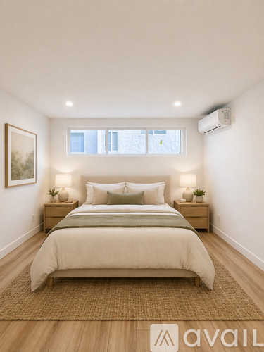 A bedroom with a large bed and two nightstands with lamps.