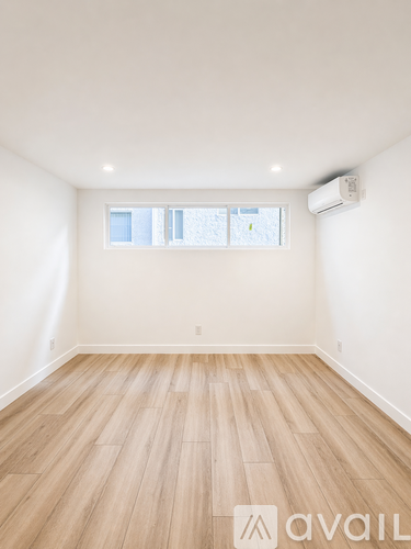 A room with wooden flooring and a window.