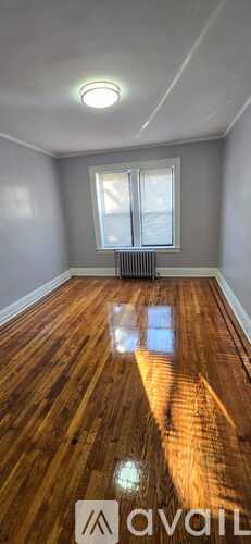 A room with wooden flooring and a window.