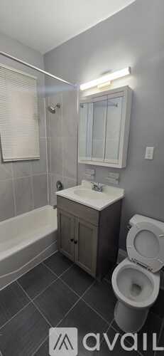 A bathroom with a toilet, sink, and bathtub.