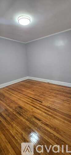 A room with wooden flooring and a ceiling light.