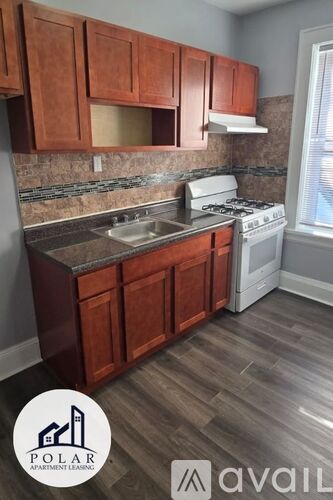 A kitchen with wooden cabinets and a white stove top oven.