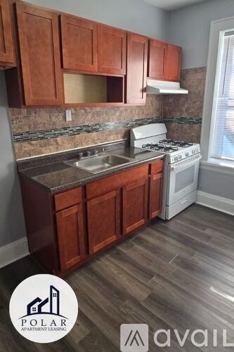 A kitchen with wooden cabinets and a white stove top oven.