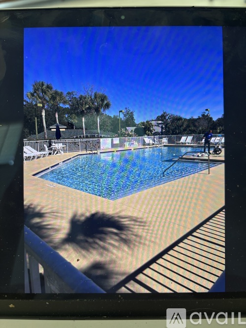 A pool with blue water and a person standing on the edge.