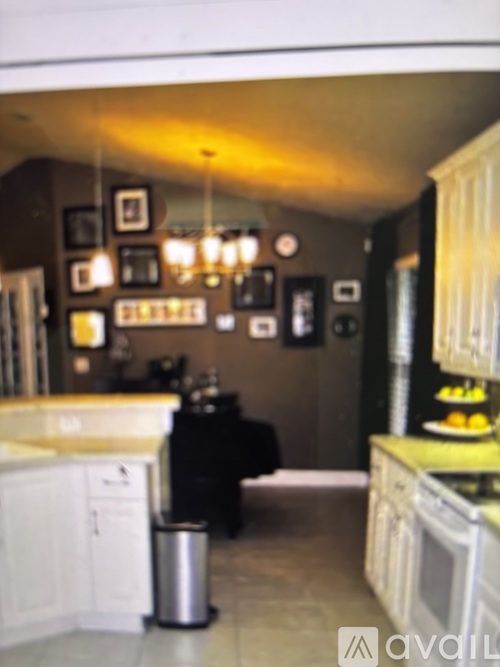 A kitchen with white cabinets and a black fridge.