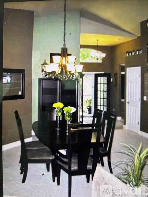 A dining room with a black table and chairs.