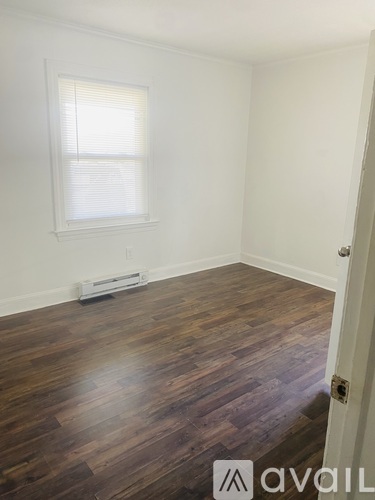 A room with wooden flooring and a window.