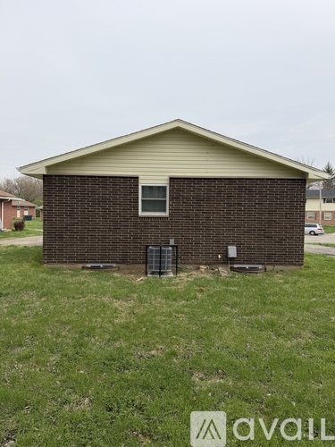 A small house with a brick exterior and a gated entrance.