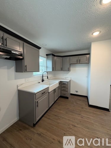 A kitchen with wooden floors and white countertops.