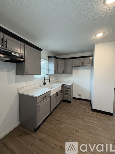 A kitchen with wooden floors and white countertops.