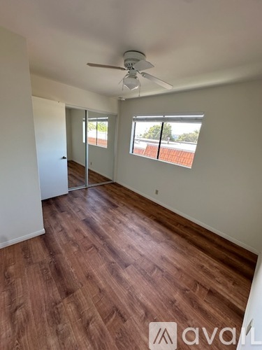 A room with wooden flooring and a ceiling fan.