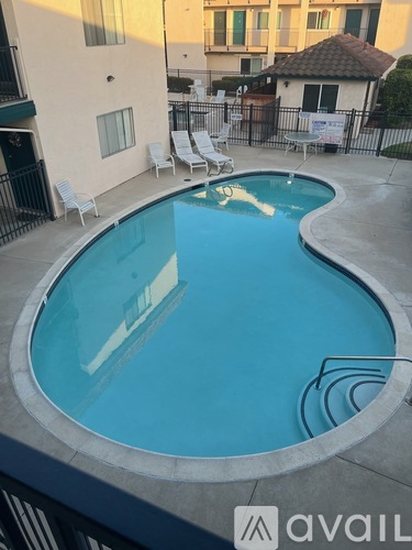 A small pool with a concrete edge and a metal railing.
