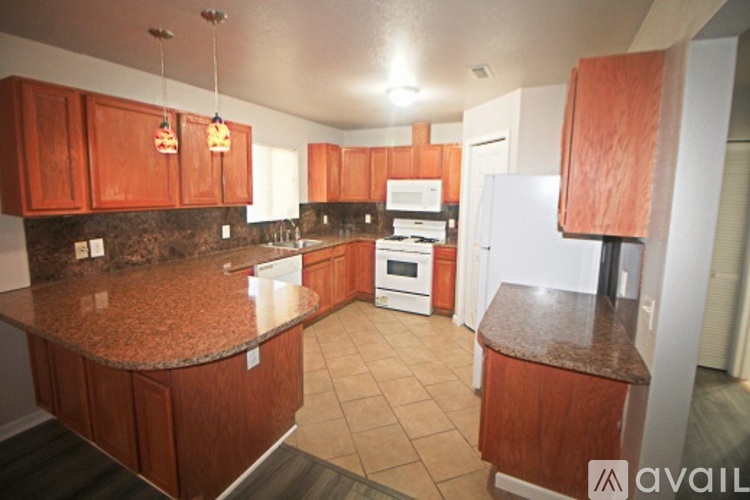 A kitchen with brown cabinets and a granite counter top.