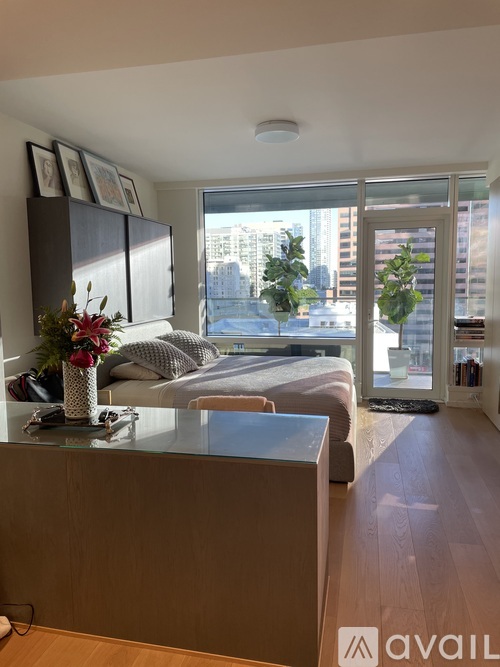 A modern bedroom with a large bed and a view of the city.