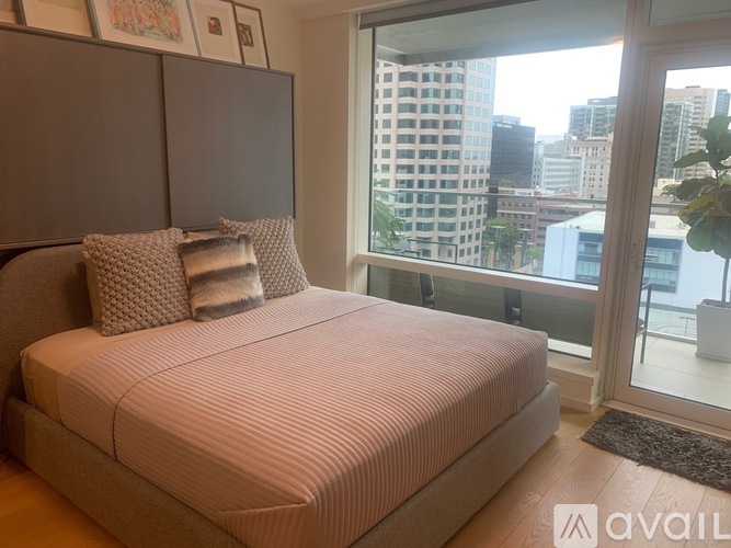 A bedroom with a large bed and a view of the city.