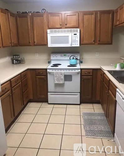 A kitchen with wooden cabinets and white appliances.
