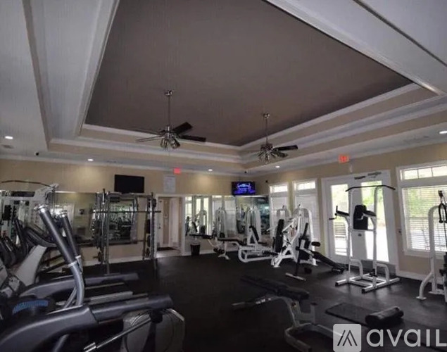 A gym with a variety of equipment including treadmills, weights, and exercise machines.
