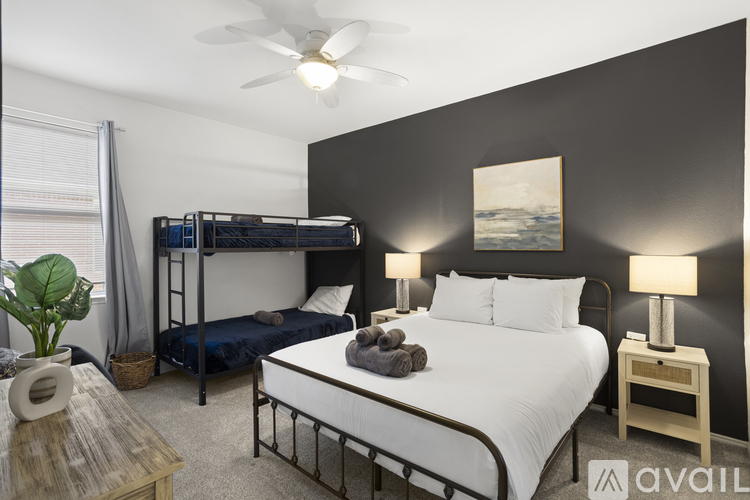 A bedroom with a bunk bed and a single bed with pillows and blankets.