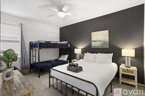 A bedroom with a bunk bed and a single bed with pillows and blankets.