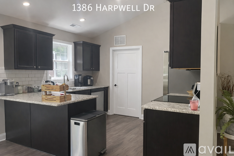 A kitchen with black cabinets and a white door.