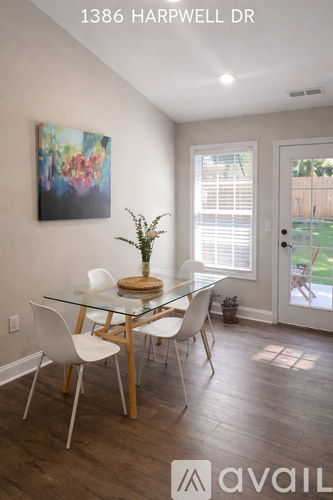 A dining room with a glass table and white chairs.