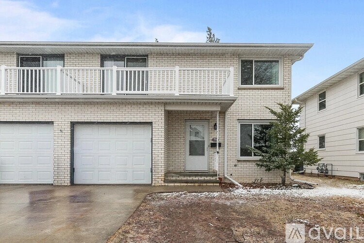 A two-story house with a balcony and a garage.