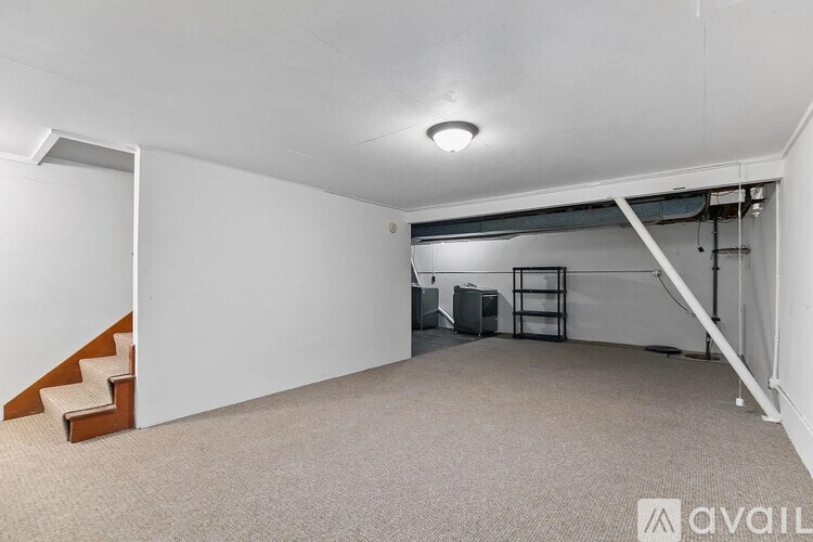 A spacious room with a staircase and a carpeted floor.
