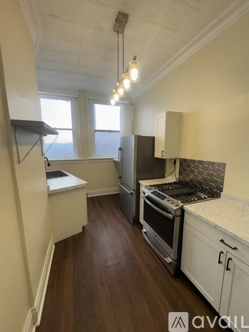 A kitchen with wooden floors and white cabinets.