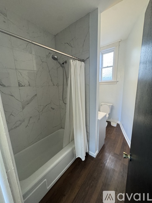 A bathroom with a walk-in shower and a window.