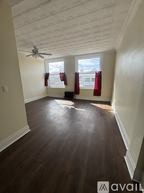 A room with wooden floors and a ceiling fan.