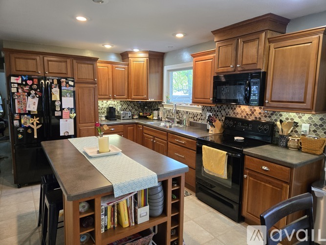 A kitchen with wooden cabinets and black appliances.