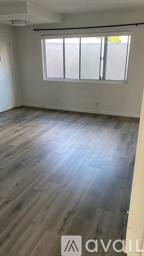 A room with wooden flooring and a window.