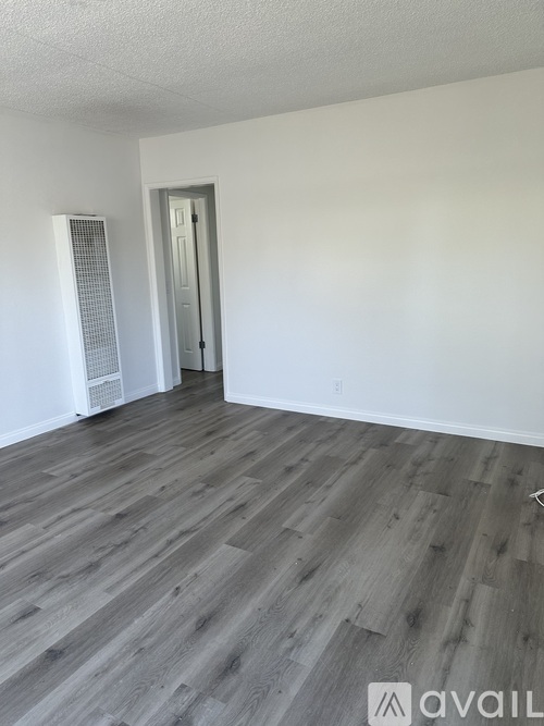 A room with wooden flooring and a door.