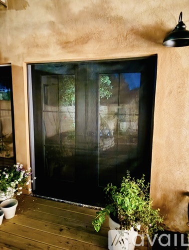 A glass door with a reflection of a building and trees.