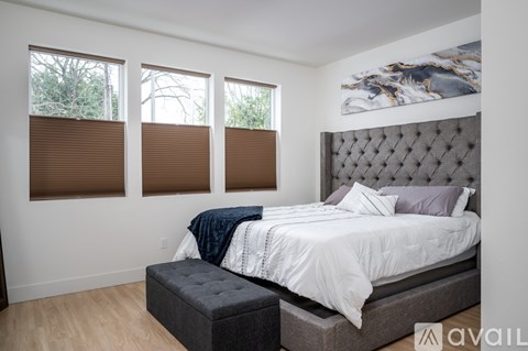 A bedroom with a large bed and a bench in front of it.