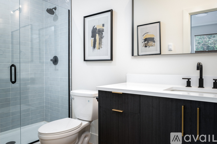 A bathroom with a toilet, sink, and mirror.