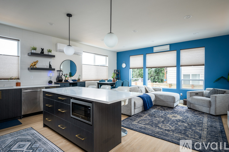 A modern kitchen with a large island and a blue accent wall.