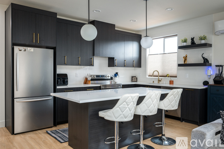 A modern kitchen with a large island and bar stools.
