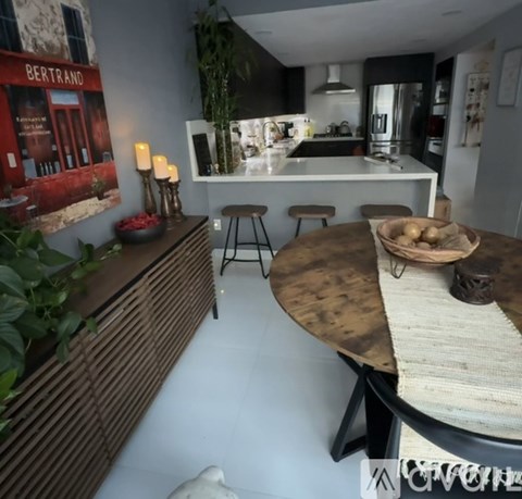 A modern kitchen with a wooden table and stools.