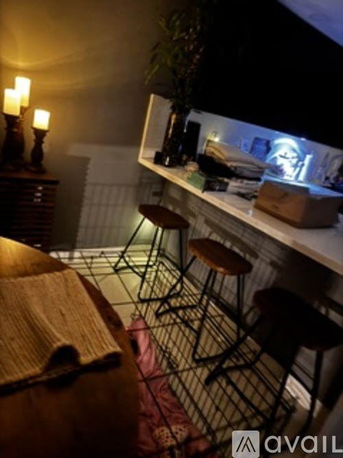 A dimly lit bar area with a counter and stools.