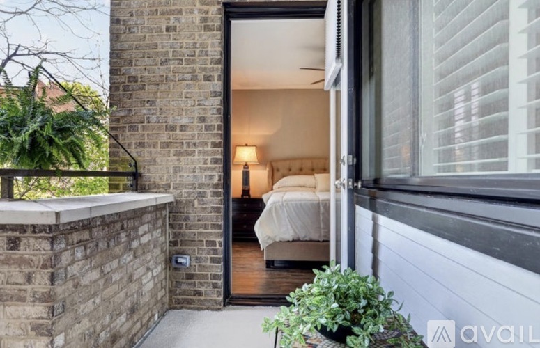 A bedroom with a bed and a lamp is visible through an open door.