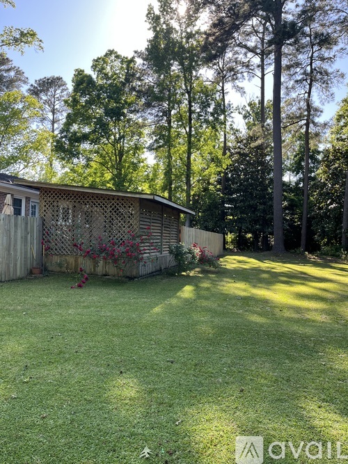 A house with a fence and trees in the background.
