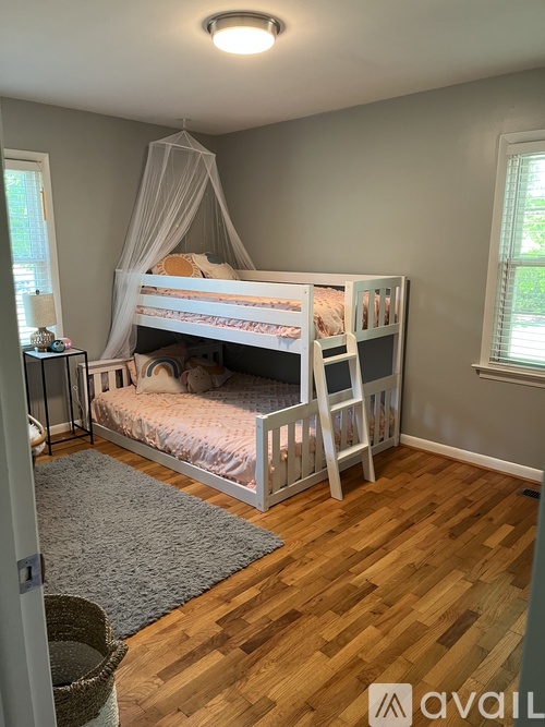 A bedroom with a bunk bed and a window.