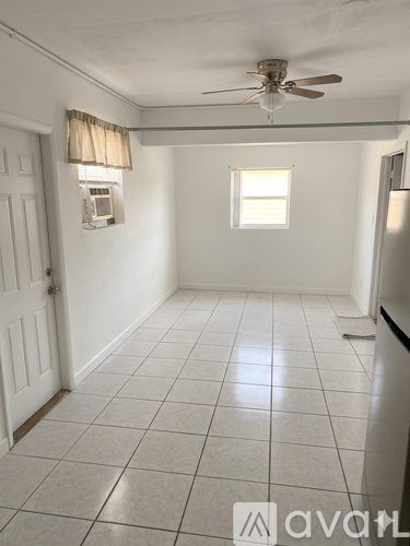 A room with a ceiling fan and a window with blinds.