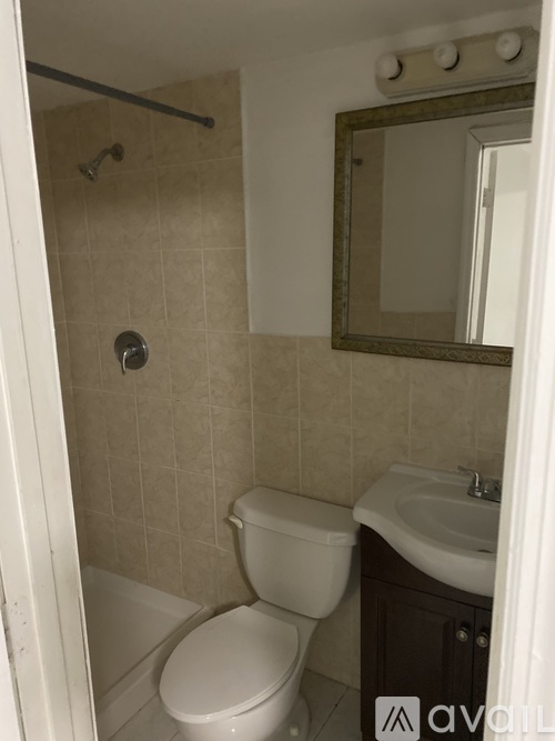 A bathroom with a toilet, sink, and mirror.
