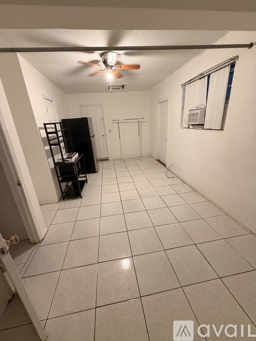 A room with a ceiling fan and a black cabinet.