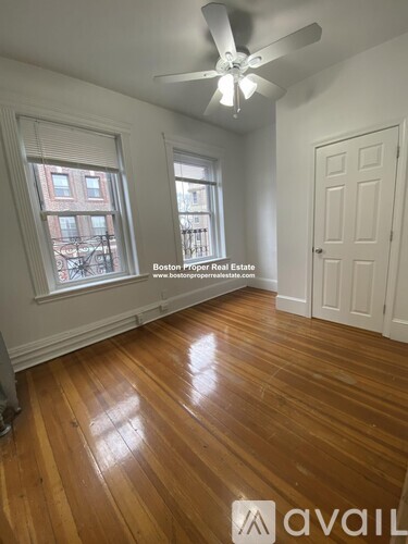 A room with wooden floors and a ceiling fan.