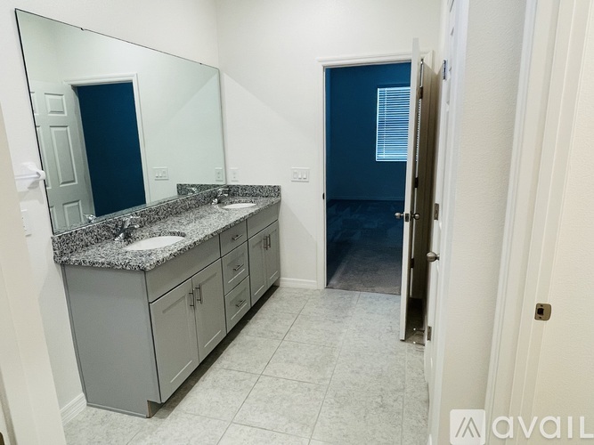 A bathroom with a sink, mirror, and cabinets.