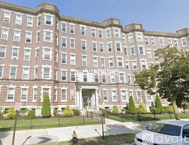A large red brick building with a sign that says "Sunrise Prop Real Estate" on it.